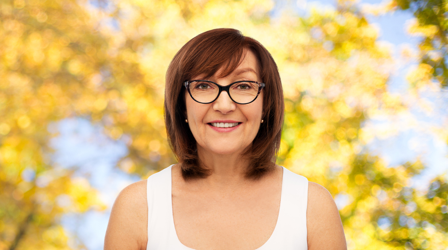 Portrait of Senior Woman in Glasses over Autumn