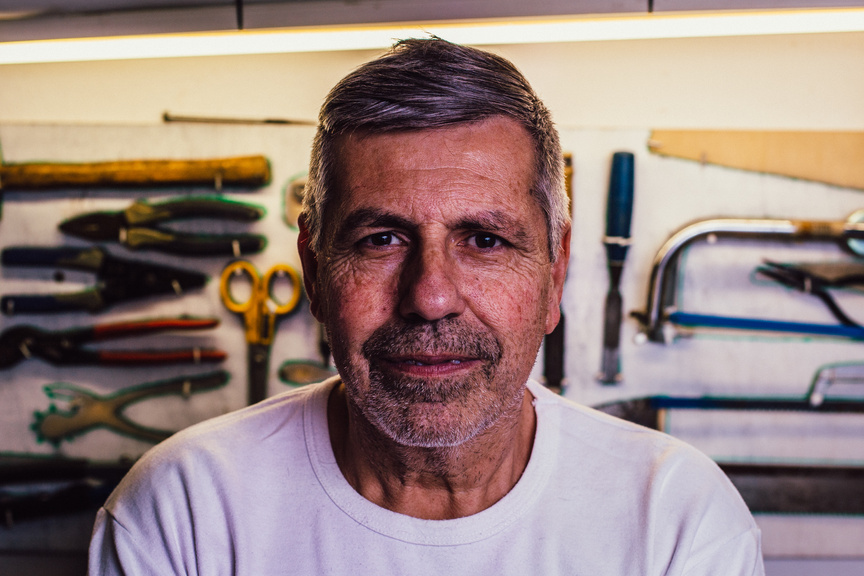 Portrait Photo of Man in White Crew-neck T-Shirt With Assorted Hand Tools in Background